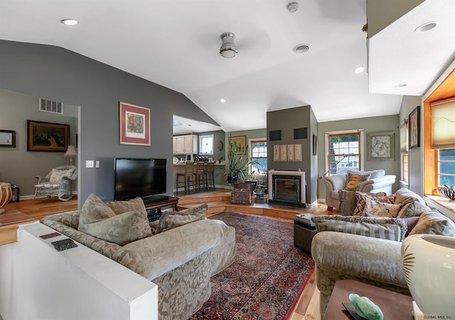 living room featuring hardwood / wood-style flooring, ceiling fan, and lofted ceiling