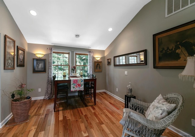 dining space featuring vaulted ceiling and hardwood / wood-style floors