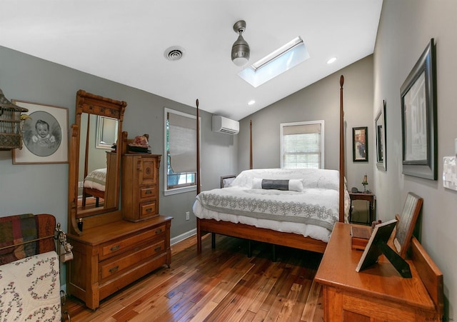 bedroom with vaulted ceiling with skylight, an AC wall unit, ceiling fan, and dark hardwood / wood-style flooring