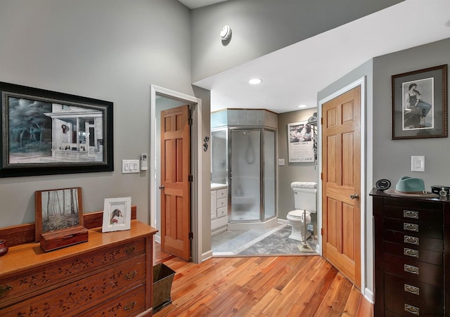 bathroom with wood-type flooring, toilet, and walk in shower