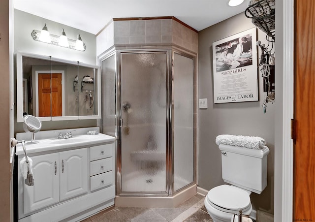 bathroom featuring toilet, tile patterned flooring, walk in shower, and vanity