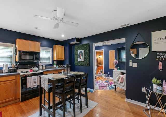 kitchen with black appliances, light wood-type flooring, and ceiling fan