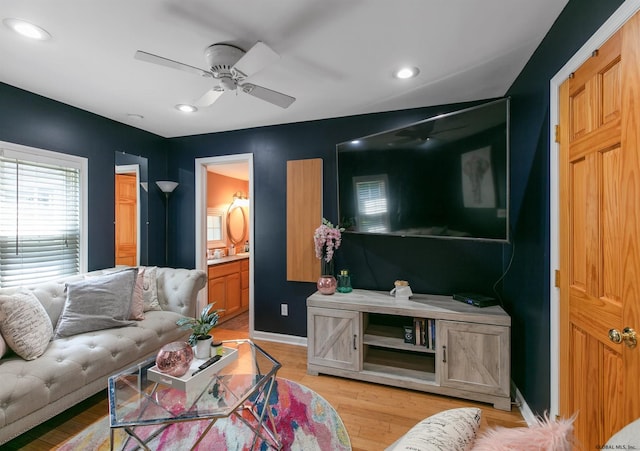 living room with light hardwood / wood-style floors and ceiling fan