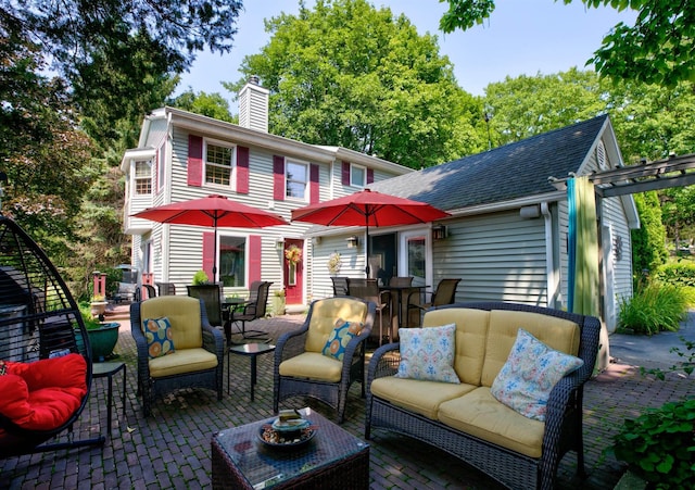 rear view of property with a patio area and outdoor lounge area