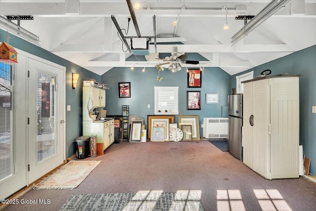 garage with heating unit, a garage door opener, and stainless steel refrigerator