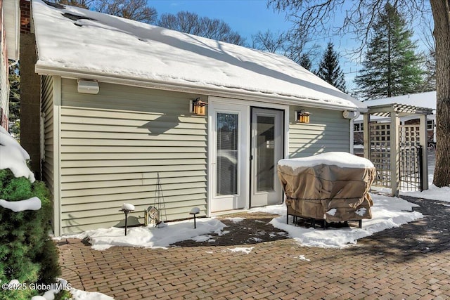 snow covered property featuring a pergola