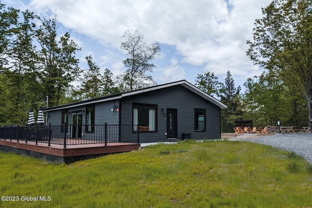 view of front of house featuring a front lawn and a deck