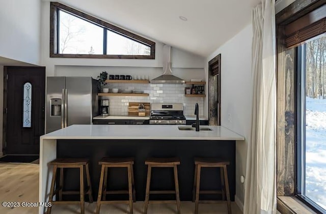 kitchen with backsplash, sink, a breakfast bar area, vaulted ceiling, and stainless steel appliances