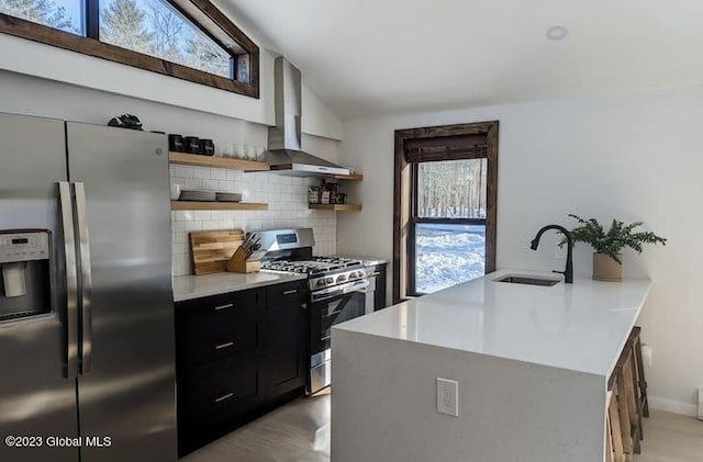 kitchen with sink, wall chimney exhaust hood, stainless steel appliances, backsplash, and lofted ceiling