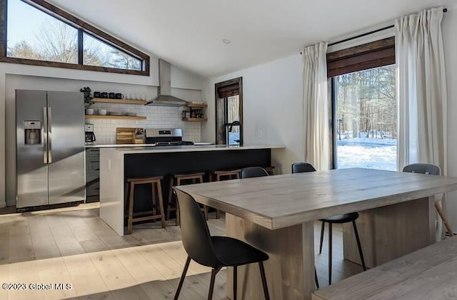 dining space with light hardwood / wood-style floors and lofted ceiling