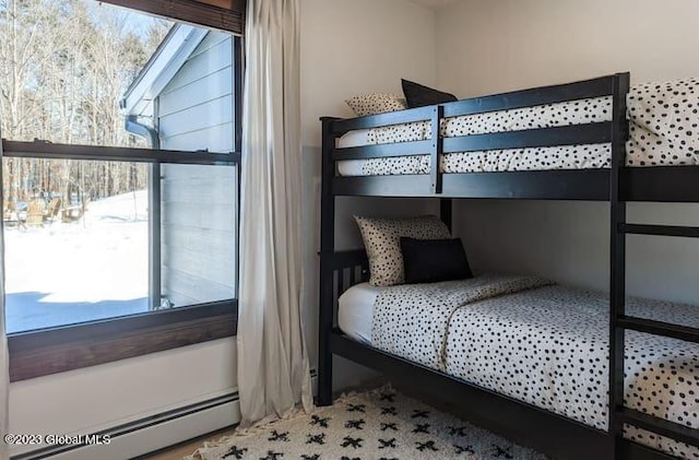 bedroom featuring multiple windows and a baseboard heating unit