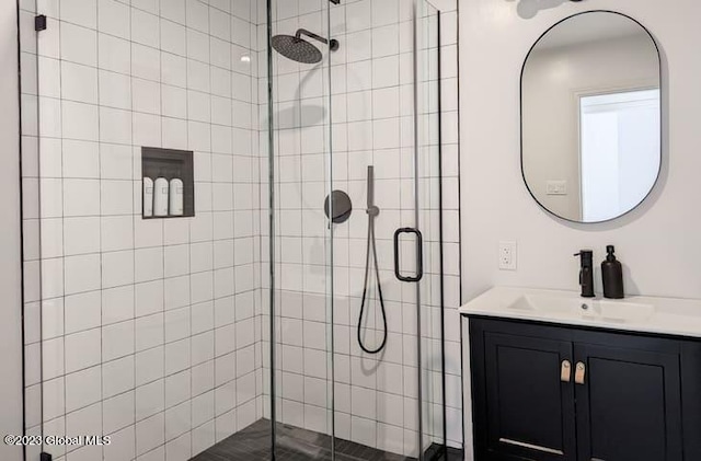 bathroom with vanity and a shower with door