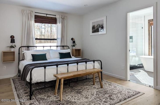 bedroom featuring light hardwood / wood-style floors and connected bathroom