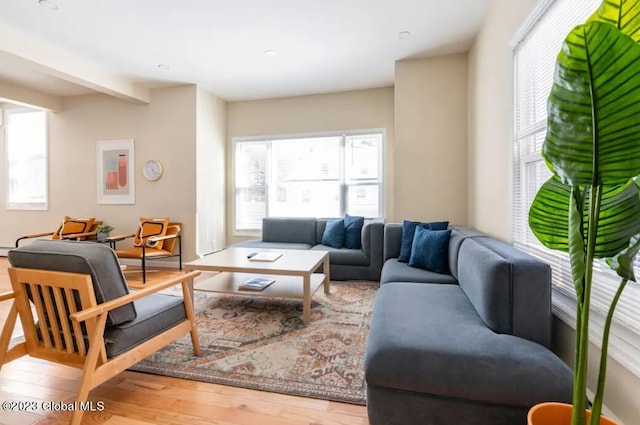 living room featuring beamed ceiling and hardwood / wood-style flooring