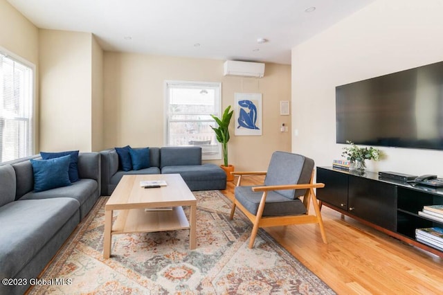 living room with light hardwood / wood-style flooring and an AC wall unit