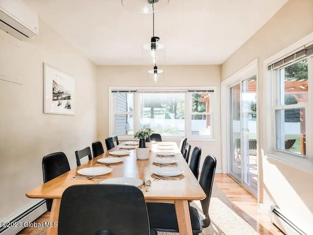 dining room with light hardwood / wood-style flooring, an AC wall unit, and a baseboard heating unit