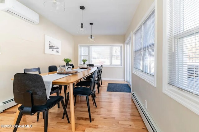 dining space with a wall unit AC, light hardwood / wood-style flooring, and a baseboard radiator