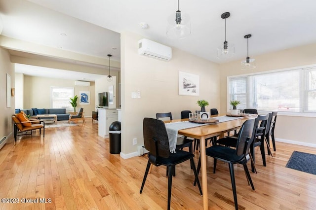 dining area featuring light hardwood / wood-style floors, a baseboard radiator, and a wall mounted AC