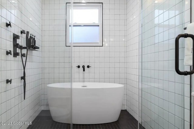 bathroom featuring walk in shower, tile patterned floors, and tile walls