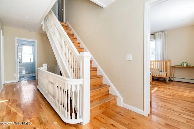 stairway featuring hardwood / wood-style flooring and baseboard heating