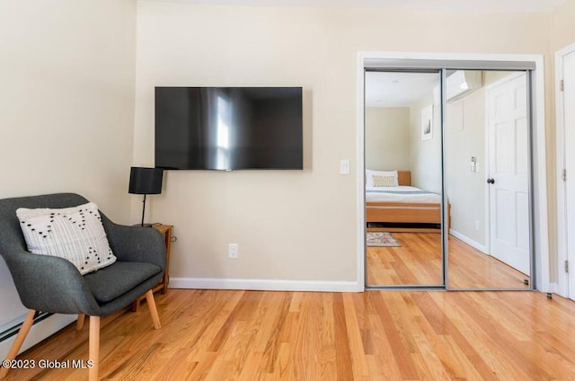 sitting room with hardwood / wood-style floors and a baseboard radiator