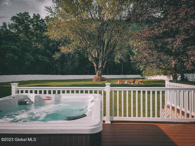 deck featuring a yard and a hot tub