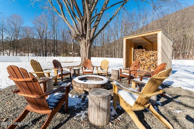 snow covered patio with a fire pit