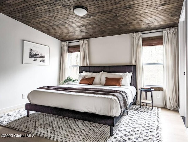 bedroom with light wood-type flooring and wood ceiling