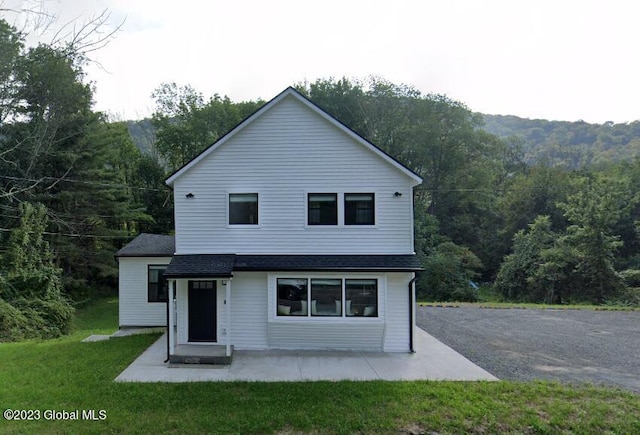 view of front of house featuring a patio area and a front yard