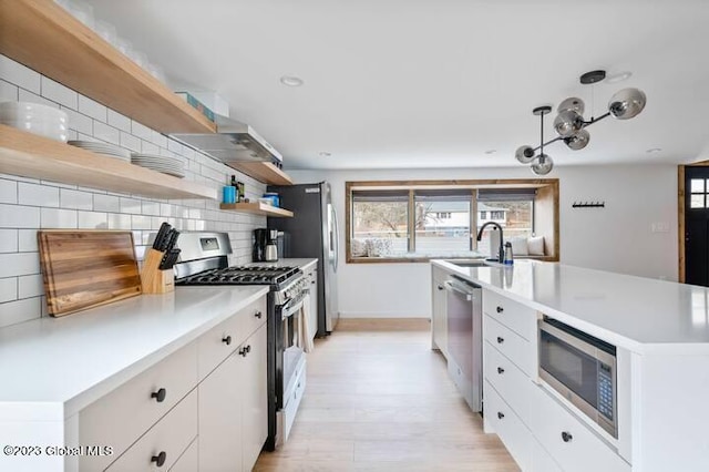 kitchen with backsplash, white cabinetry, an island with sink, and appliances with stainless steel finishes