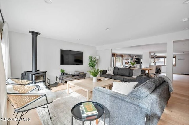 living room with light hardwood / wood-style floors and a wood stove