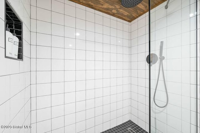 bathroom featuring a tile shower and wood ceiling