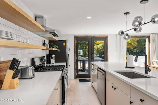 7913 Main St, Hunter, NY 12442 - kitchen featuring sink, tasteful backsplash, light hardwood / wood-style flooring, pendant lighting, and appliances with stainless steel finishes