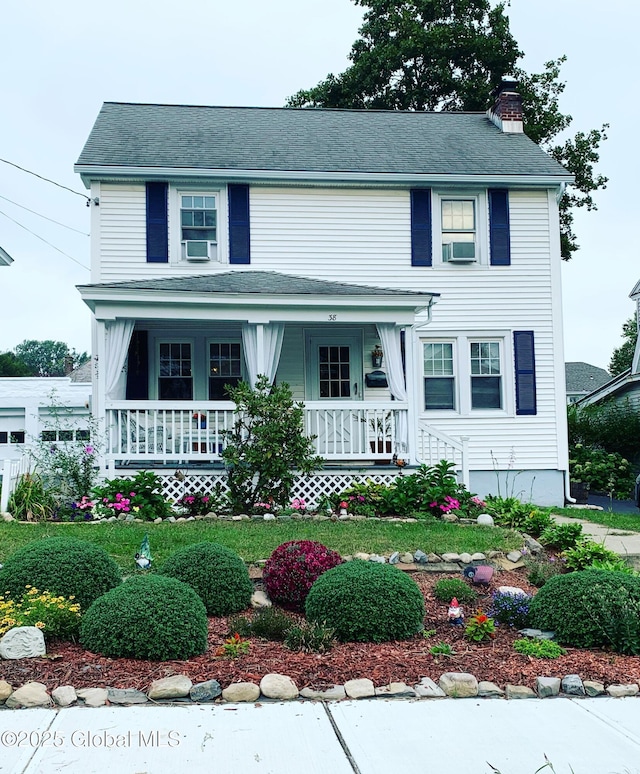 view of front facade featuring covered porch and a chimney