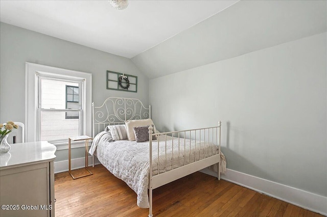 bedroom featuring lofted ceiling, light wood-style flooring, and baseboards