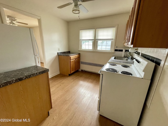 kitchen featuring radiator, sink, white refrigerator, light hardwood / wood-style floors, and range