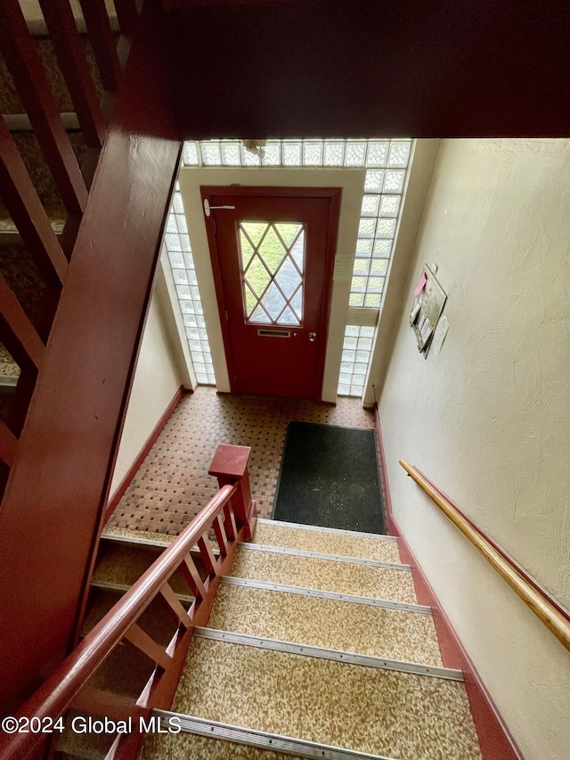 stairway featuring carpet flooring