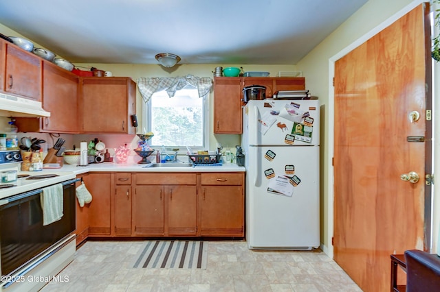 292 N Main St, Northville, NY 12134 - kitchen featuring white appliances, under cabinet range hood, a sink, light countertops, and brown cabinetry