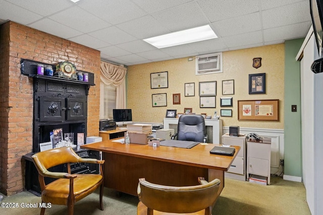 carpeted office with an AC wall unit and a paneled ceiling