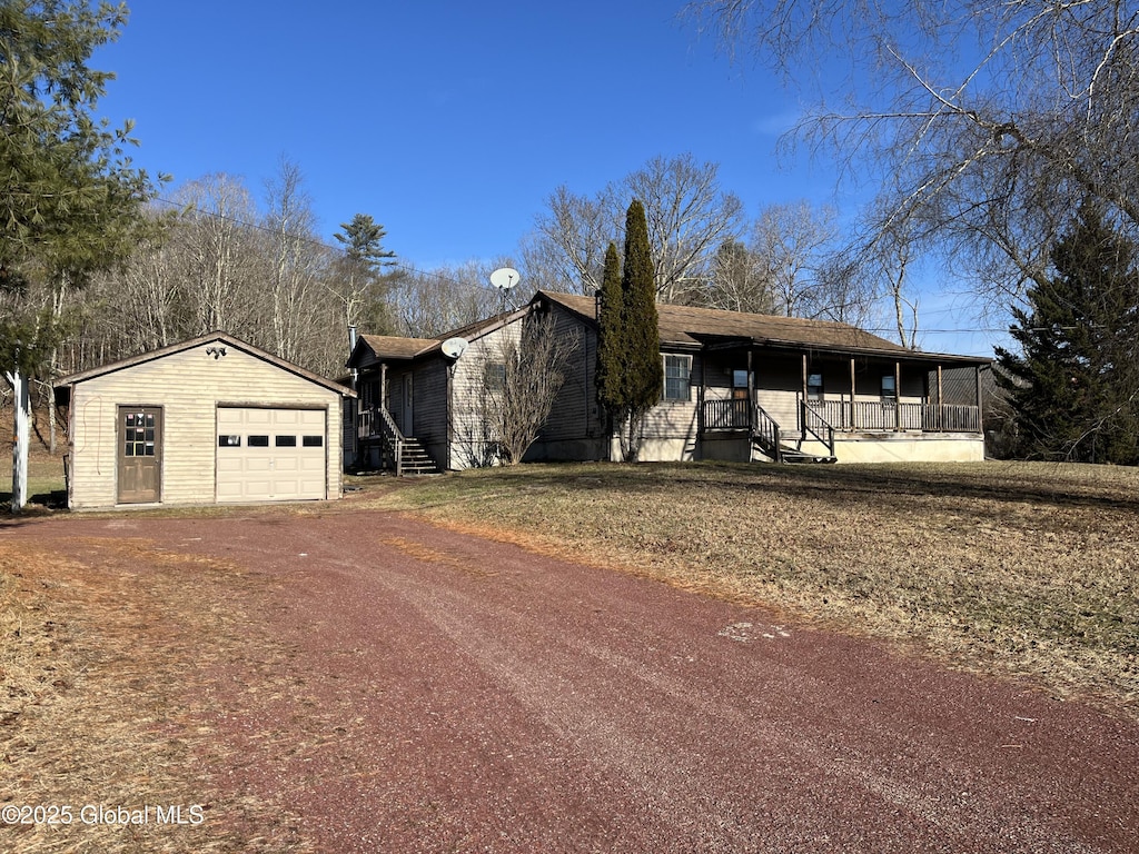 view of front facade featuring a sunroom, a garage, and an outdoor structure