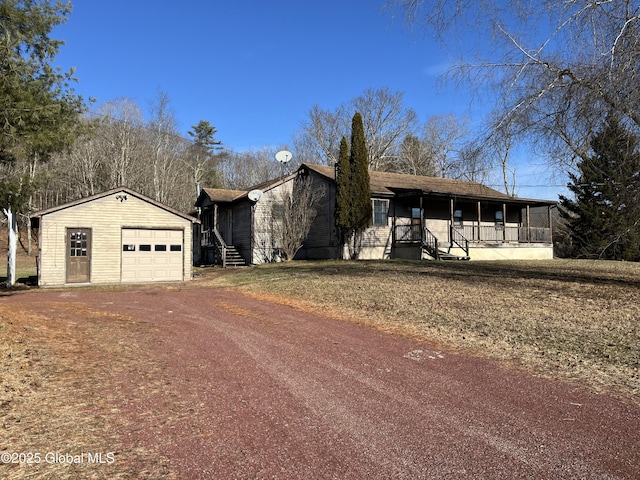 view of front facade featuring a sunroom, a garage, and an outdoor structure