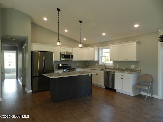 kitchen with appliances with stainless steel finishes, a center island, white cabinetry, and sink