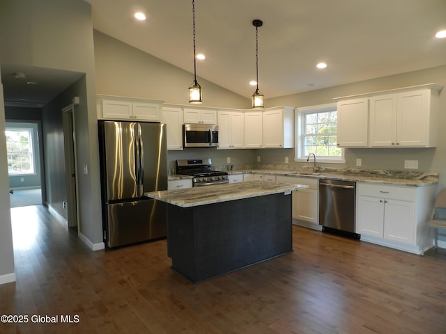 kitchen featuring light stone countertops, white cabinetry, a center island, and stainless steel appliances