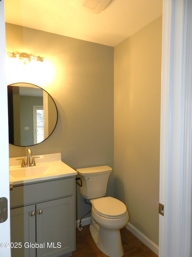 bathroom featuring wood-type flooring, vanity, and toilet