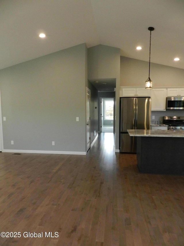 kitchen with stainless steel appliances, dark wood-type flooring, pendant lighting, white cabinetry, and lofted ceiling