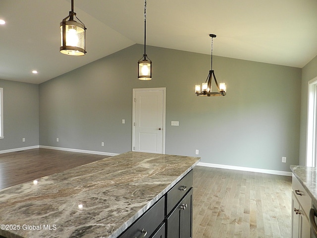 71 Bluebird Rd, Moreau, NY 12803 - kitchen with lofted ceiling, wood finished floors, light stone countertops, hanging light fixtures, and open floor plan