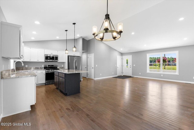 71 Bluebird Rd, Moreau, NY 12803 - kitchen with appliances with stainless steel finishes, a chandelier, open floor plan, dark wood-style flooring, and light stone countertops