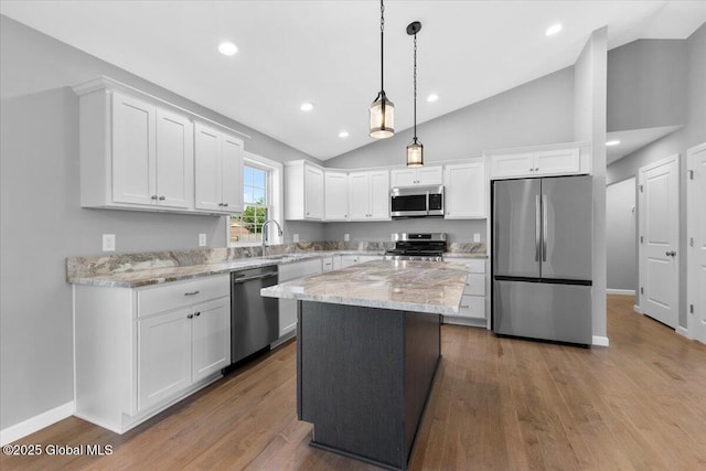 71 Bluebird Rd, Moreau, NY 12803 - kitchen with stainless steel appliances, vaulted ceiling, white cabinets, light stone countertops, and recessed lighting