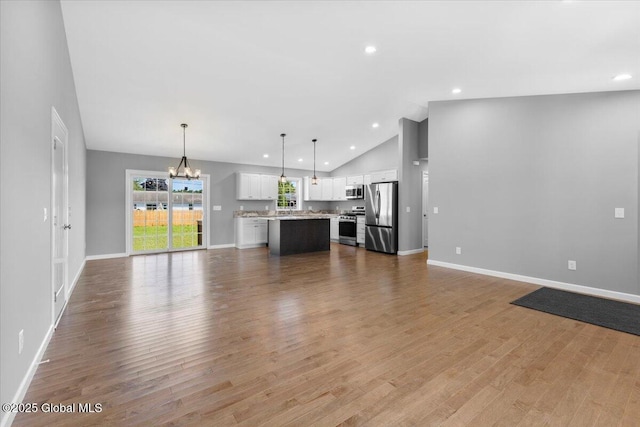 71 Bluebird Rd, Moreau, NY 12803 - unfurnished living room with vaulted ceiling, a chandelier, wood finished floors, and recessed lighting