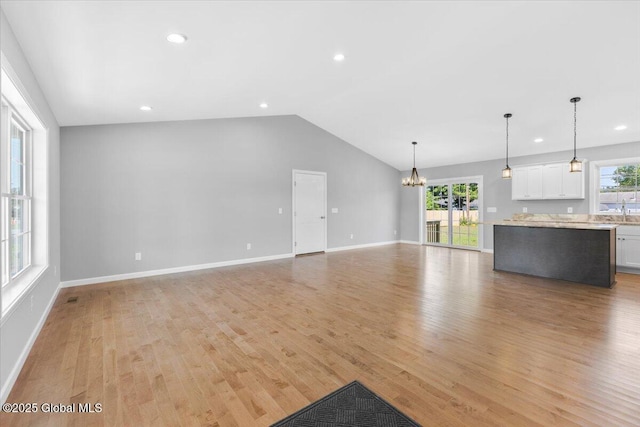 71 Bluebird Rd, Moreau, NY 12803 - unfurnished living room with a chandelier, plenty of natural light, light wood-style floors, lofted ceiling, and recessed lighting